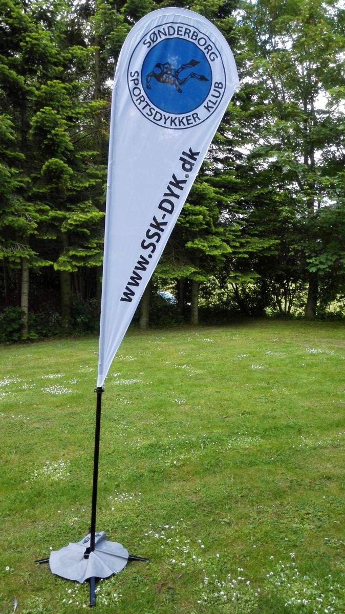 Den grå ’badering’ kan fyldes med vand, og hjælper til at holde flaget på plads i vinden
